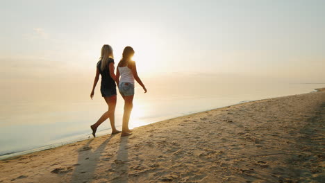 Mamá-Con-Una-Hija-De-8-Años-Caminando-Juntos-Por-La-Playa-Vista-Posterior