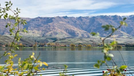 serene autumn scene at lake dunstan with calm waters, vibrant leaves, and majestic mountains under clear skies