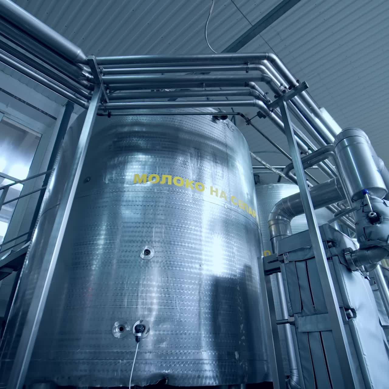 Large steel cistern for milk. Modern equipment inside the factory for production of dairy products. Close up with gradual distancing