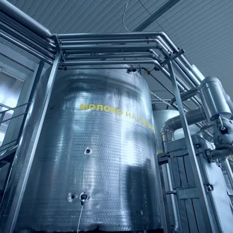 large steel cistern for milk. modern equipment inside the factory for production of dairy products. close up with gradual distancing