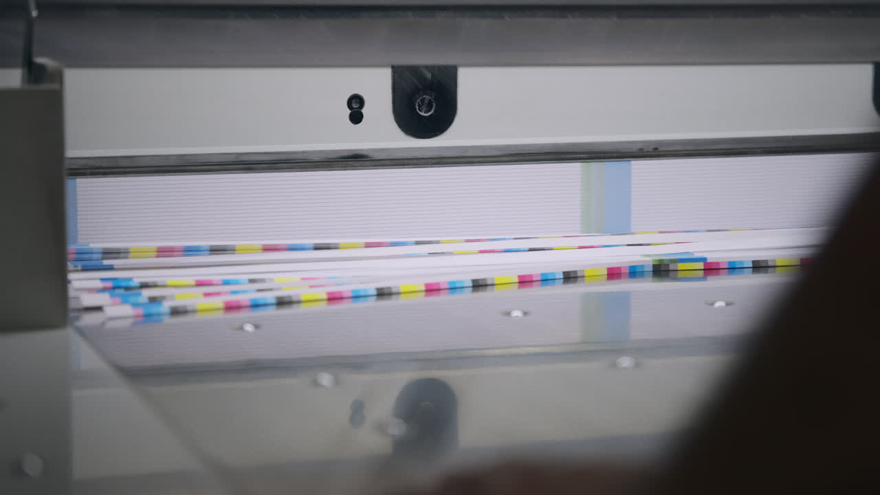 mechanized guillotine cutting a pile of paper slow motion