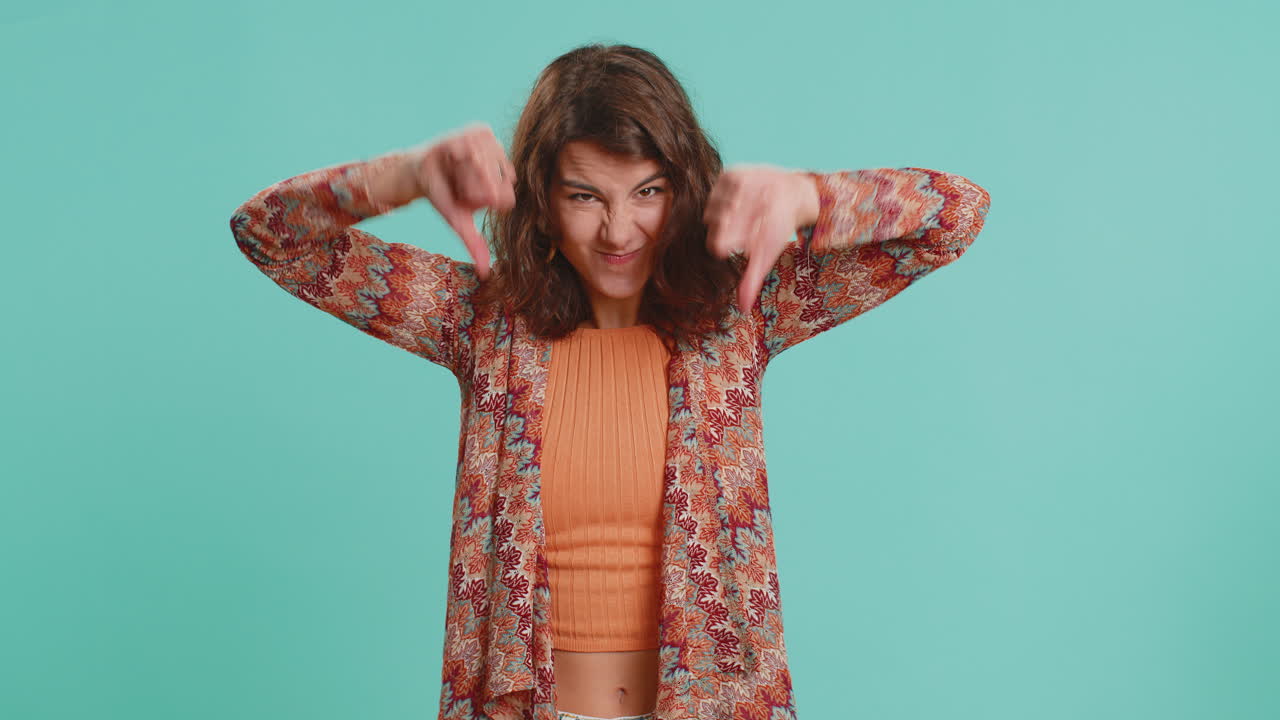 Upset attractive young woman girl showing thumbs down sign gesture disapproval dissatisfied dislike