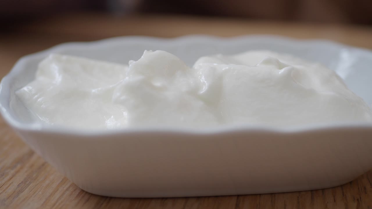 primer plano de un tazón de yogur blanco