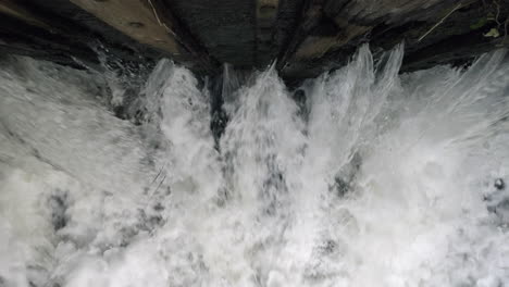 the raging waters of the river alne in warwickshire, england as it passes through sluice gates that control the amount of flood water after torrential rainfall