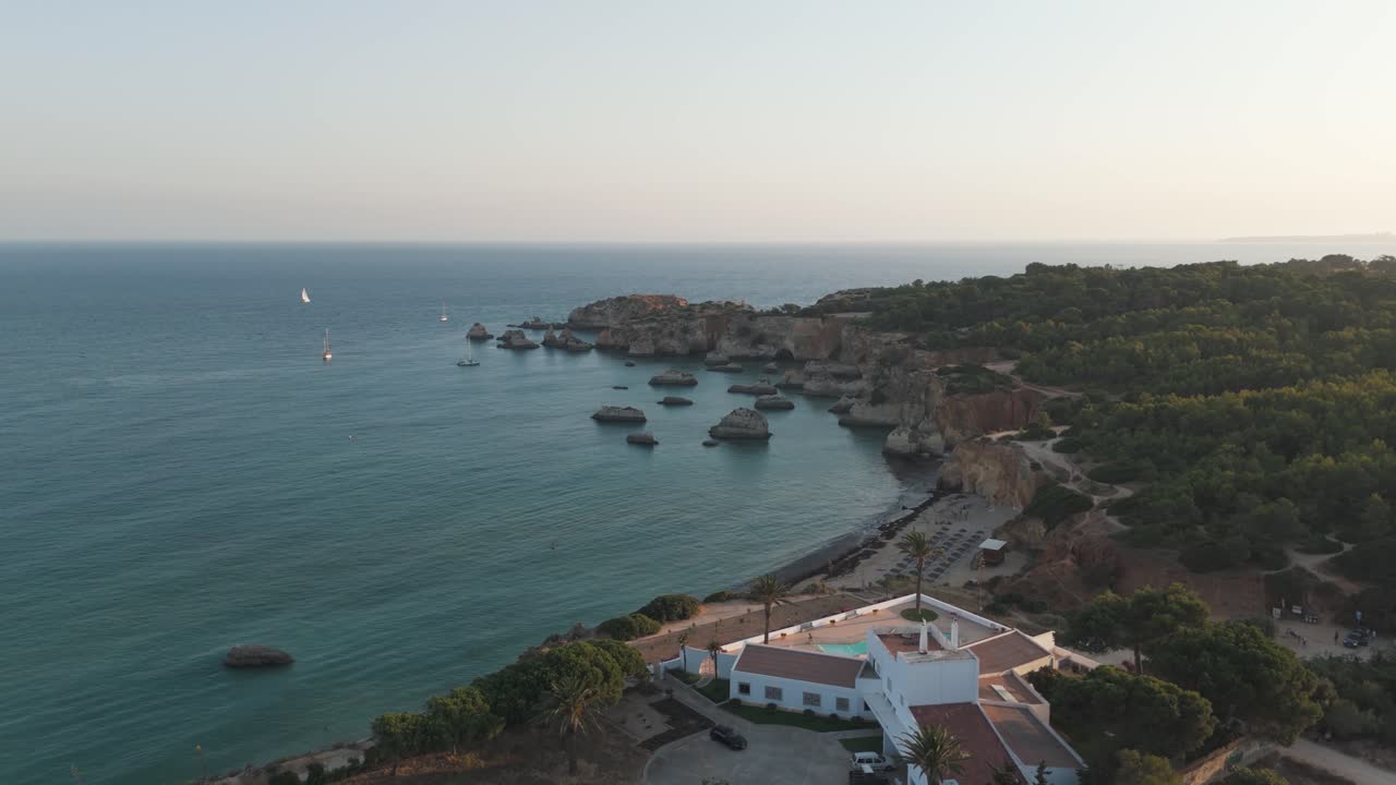 Scenic aerial landscape of Portugal's Alvor coastline with stunning cliffs and ocean. Dolly Shot
