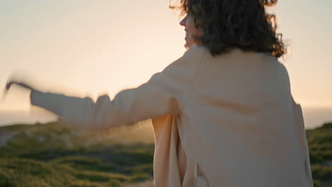 Happy-girl-going-sunset-seashore-rear-view.-Cheerful-woman-rejoicing-in-sunlight