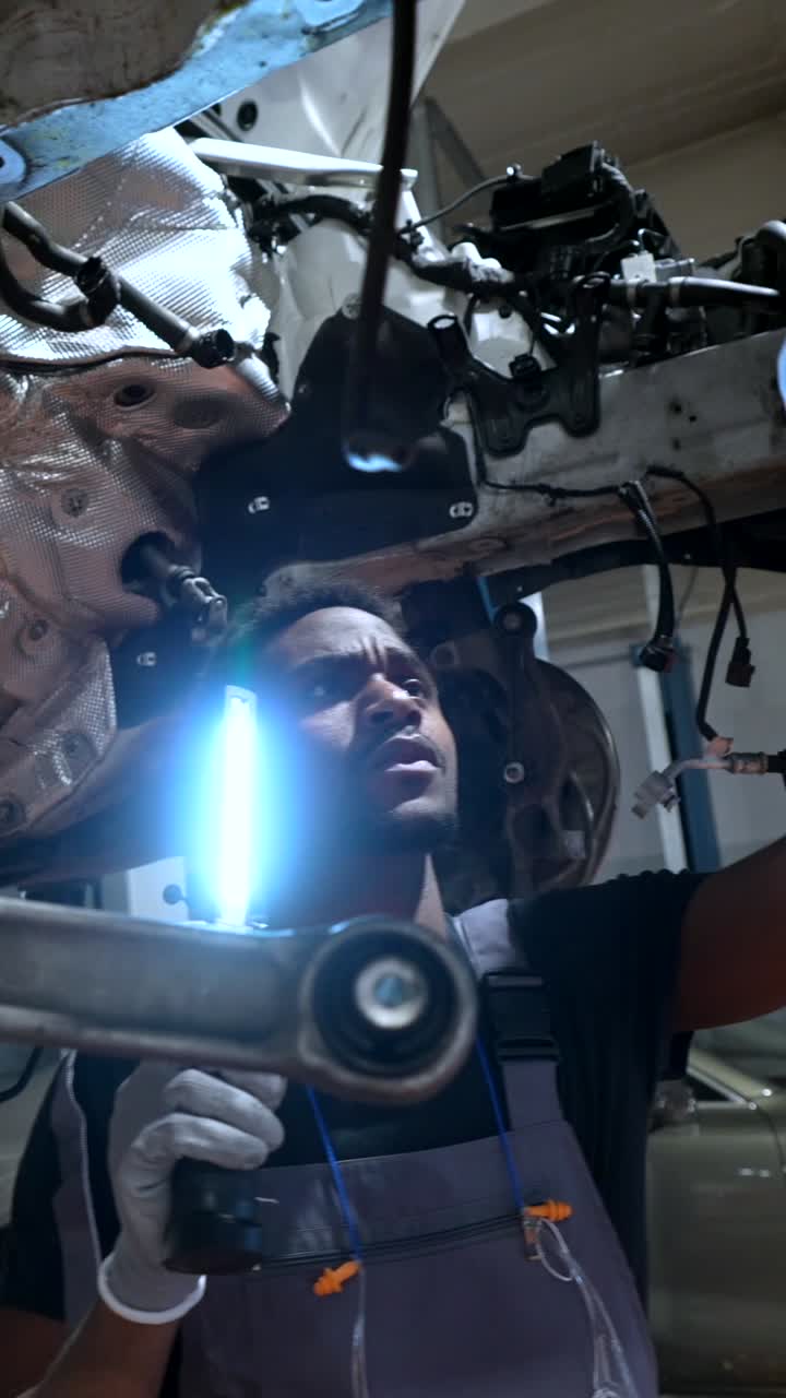 Car Mechanic Working Under Car