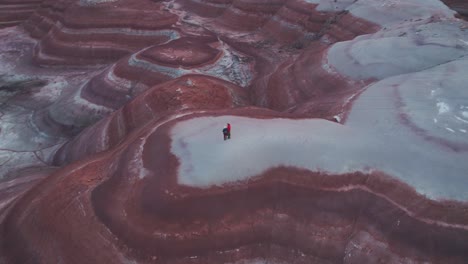 Luftaufnahme-Der-Bentonit-Hügel-In-Utah-In-Der-Blauen-Stunde-Aus-Einem-Kreis-Von-Oben,-Der-Die-Farbenfrohe,-Marsähnliche-Landschaft-Mit-Der-Perspektive-Eines-Wanderpaares-Zeigt