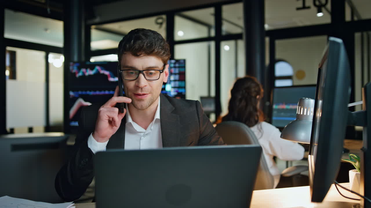 Smiling businessman talking smartphone at investment graph. Successful salesman