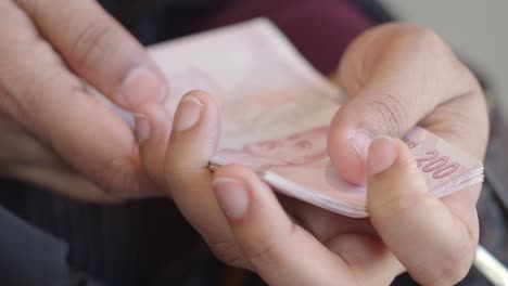 hands holding turkish lira banknotes