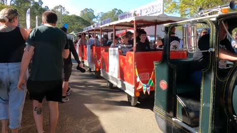 crowd enjoying a vintage train ride at a sunny event