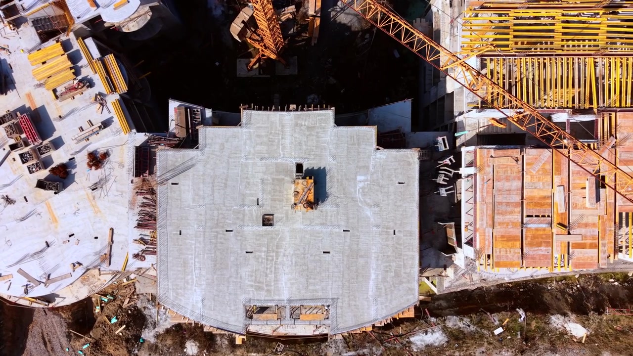 Csoncrete structures, formwork materials, and ground site elements. Top down drone perspective of apartment building foundation