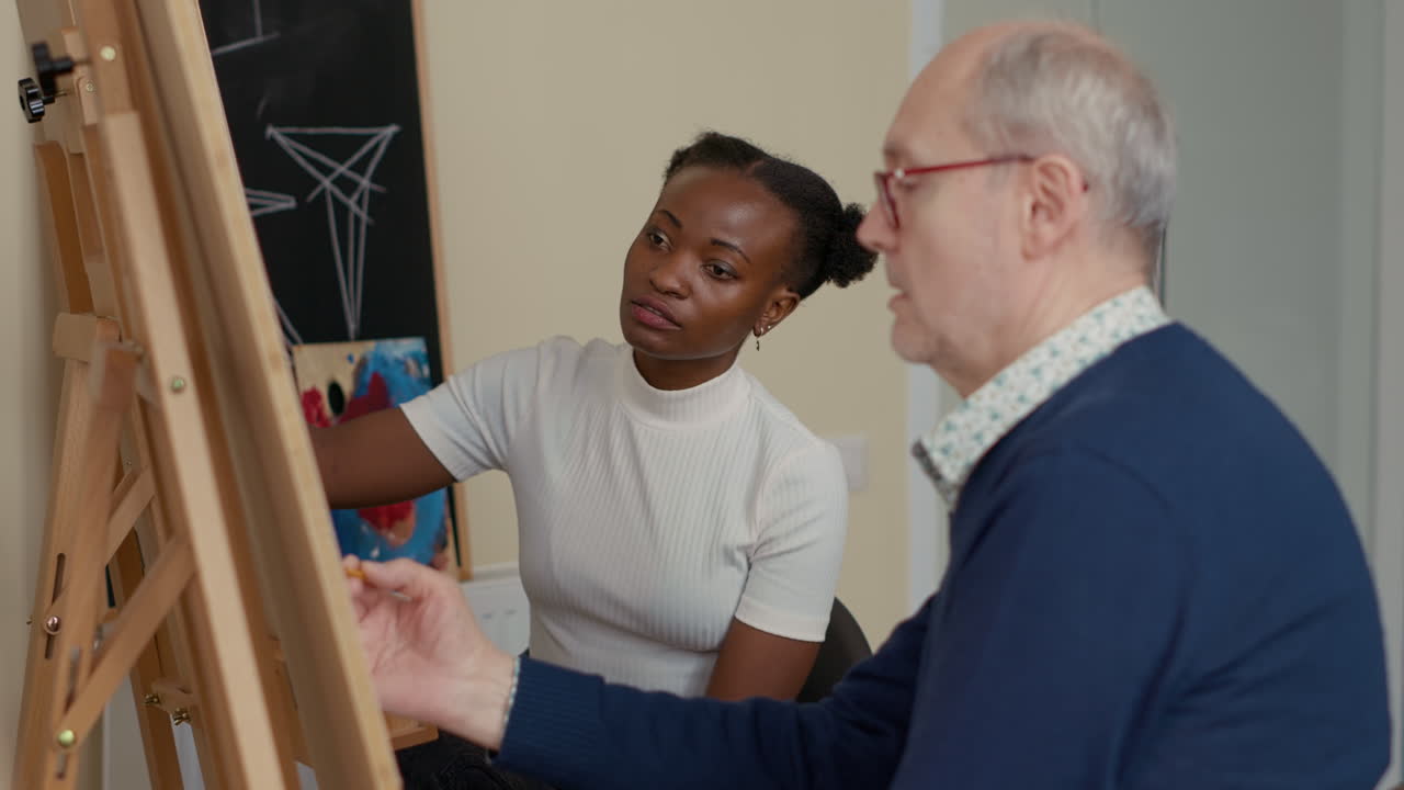 Multiethnic team of woman and man drawing on canvas together