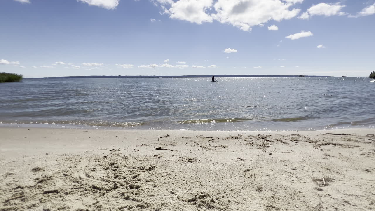 작은 파도가 크리니카 모르스카에 있는 비스툴라 석호의 해안을 강타합니다.