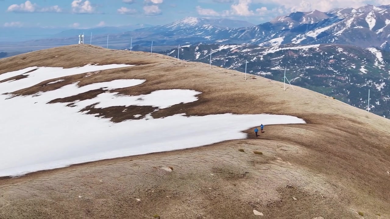 Vandrere går på en sneklædt bakketop. Panoramisk vinterlandskab fra luften over Kirgisistan. Eventyr