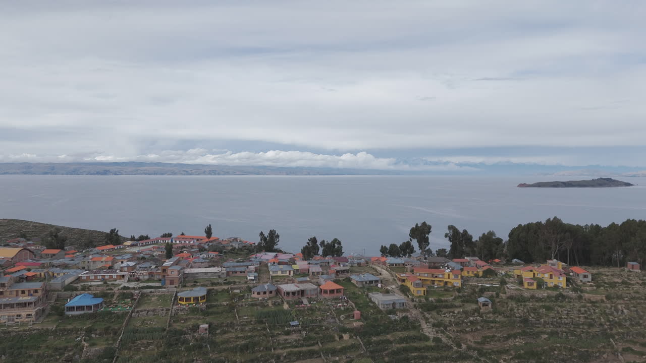 Drone shot above Isla Del Sol near Copacabana Bolivia Titicaca lake on a cloudy day with view on the sea and the islands LOG