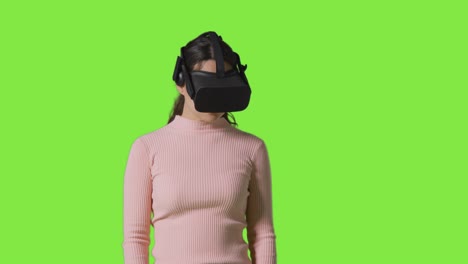 woman wearing virtual reality headset against green screen studio background