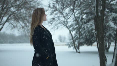 Mujer-Feliz-Afuera-En-Cámara-Lenta,-Nieve-Invernal-Navideña-Mientras-Los-Copos-De-Nieve-Caen-En-Cámara-Lenta-Cinematográfica