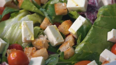 olive oil being drizzled on a fresh and healthy green salad