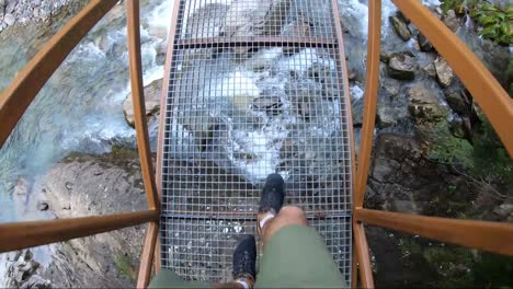 cruzando un puente de metal amarillo en el valle de ordesa, pirineos, españa