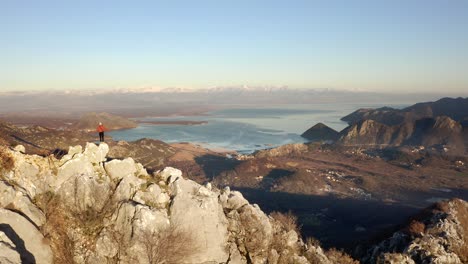 aerial - person hiking in mountains around lake skadar, montenegro, pan left reveal