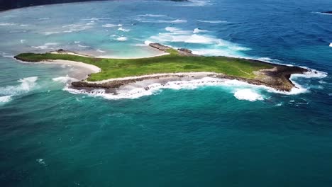 drone shot panning away from goats island, revealing the beautiful north shore coast of oahu, hawaii