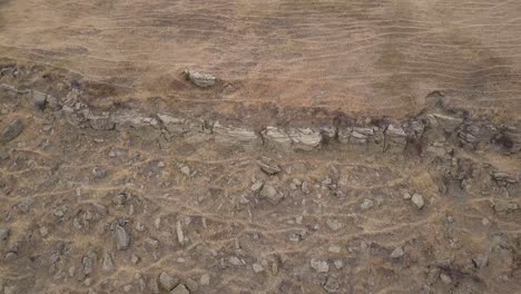 heavily eroded rocky hillside in prairie river valley with game trails