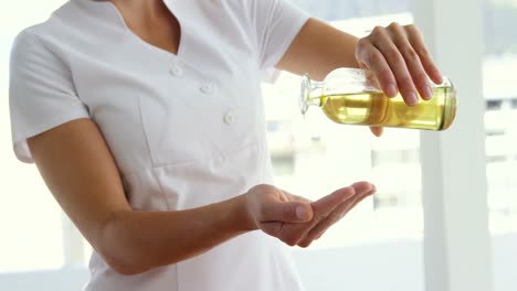 masajista vertiendo aceite de masaje en sus manos