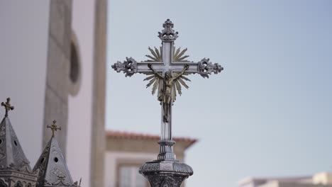 close up of ornate silver cross held outside in natural light