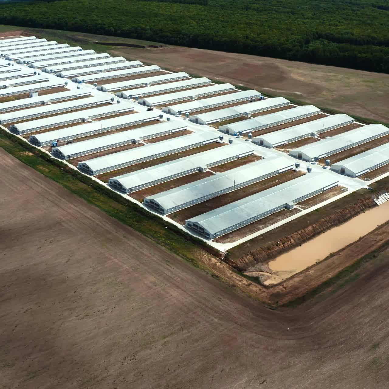 Modern production plant on the field. White buildings of innovative factory on nature background. Aerial view.