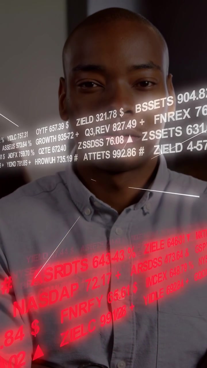 Vertical video: Man sitting arms folded, camera shifting up, tickers sweeping face showing finance