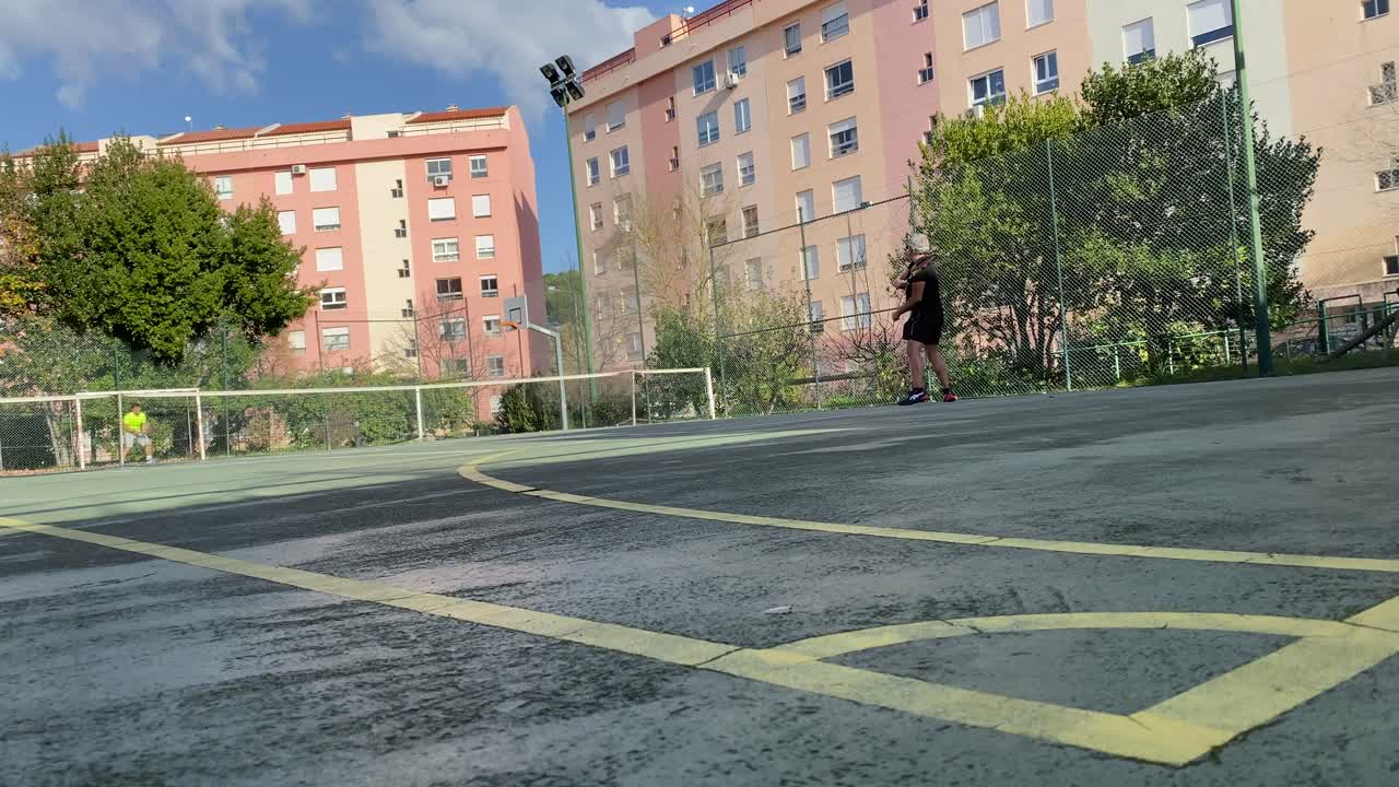 Male tennis player playing on outdoor court against male player