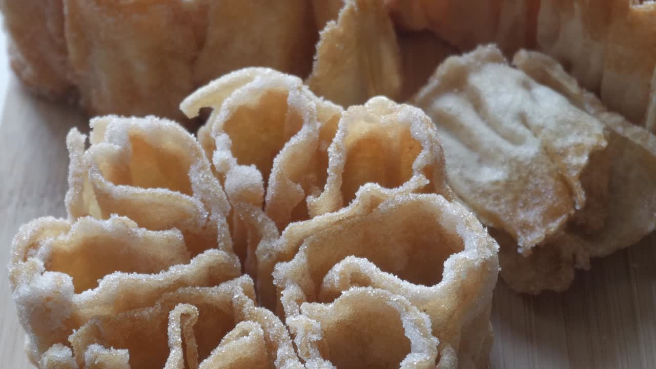 Detailed close up of a Flor Frita, a traditional Spanish sweet known as florón, resting on a wooden surface