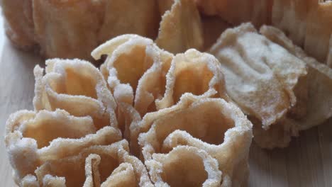 detailed close up of a flor frita, a traditional spanish sweet known as florón, resting on a wooden surface
