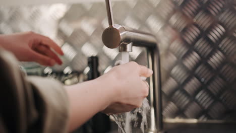 Close-up-of-woman-doing-the-dishes-at-home,-domestic-household-maintenance-concept