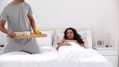 hombre guapo trayendo a su pareja el desayuno en la cama