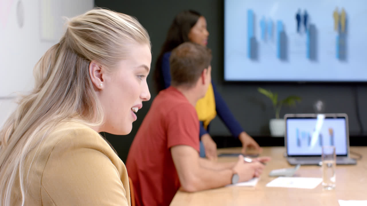 Happy caucasian casual businesswoman talking in meeting with diverse colleagues, slow motion