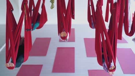 clase de yoga de mosca con damas recuperando energía en hamacas
