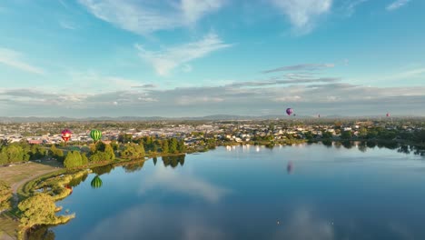 Heißluftballons-Fahren-In-Richtung-Stadt,-Aufnahmen-Zeigen-6-Ballons-Im-Rahmen-Des-Ballonfestivals-Im-März-2022