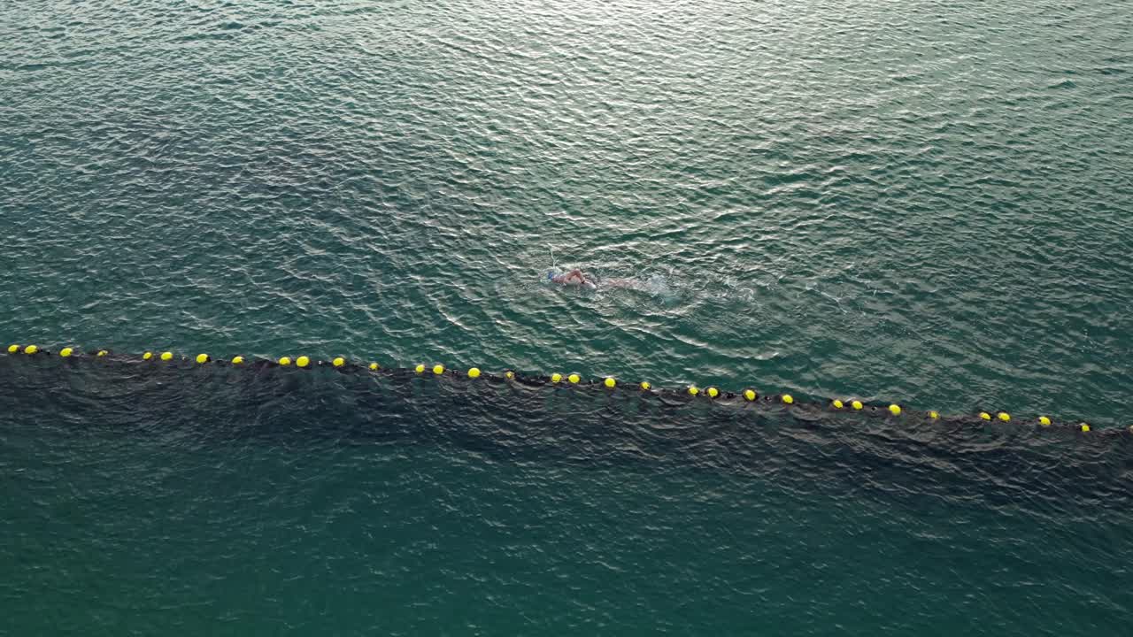 ⁇ 은 바다에서 수영하는 사람의 상승하는 드론  ⁇ 은  ⁇ 은 바다에서 해가 지는 동안