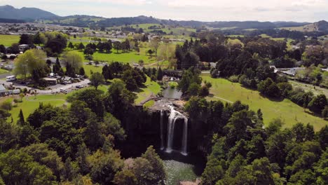 beautiful waterfall in city park aerial orbit shot