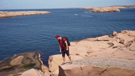 a person walking on rocky cliffs with ocean views in hovs hallar nature reserve
