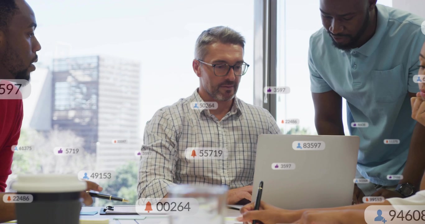 Seated lead reaching papers speaking starting business metric badges flowing over laptop for review