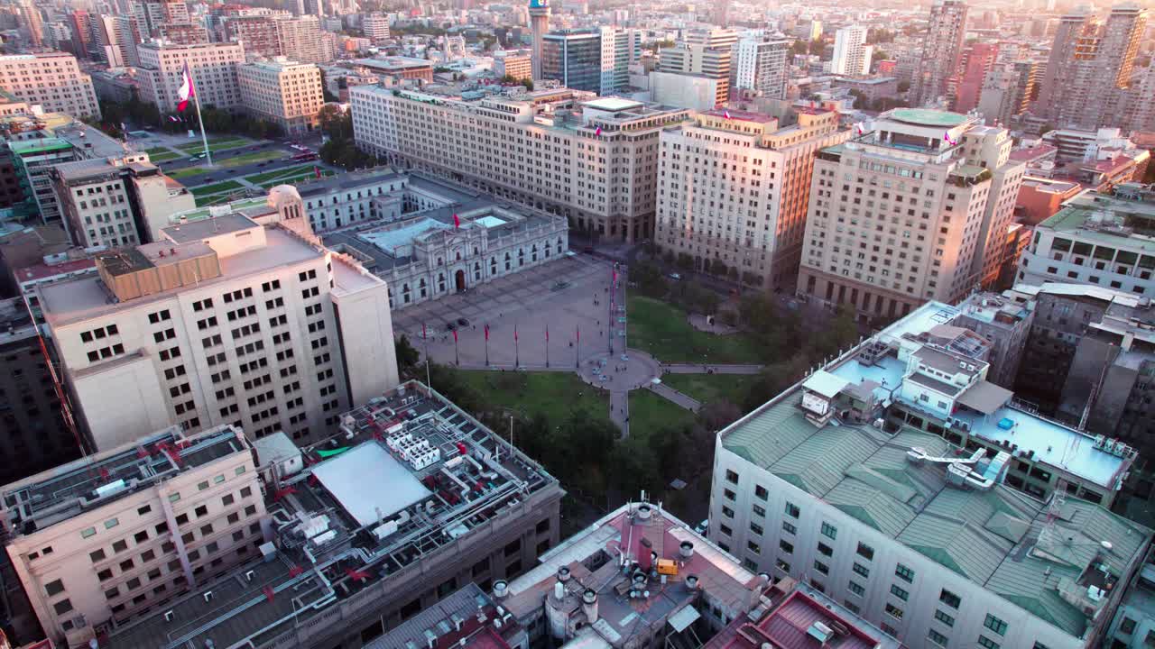 Aerial revealing shot of the Barrio C&iacute;vico, La Moneda with flags flying in the square