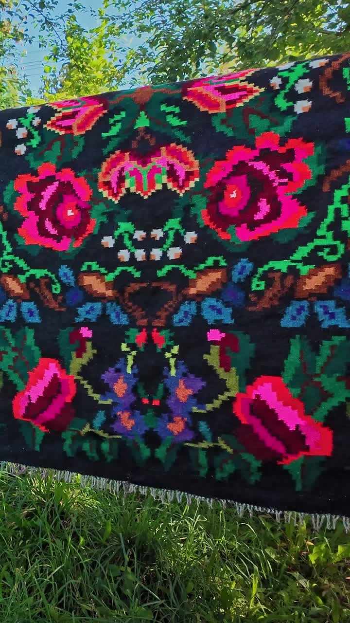 River Washed flower pattern woven carpets hang to dry in Romanian sun VERTICAL