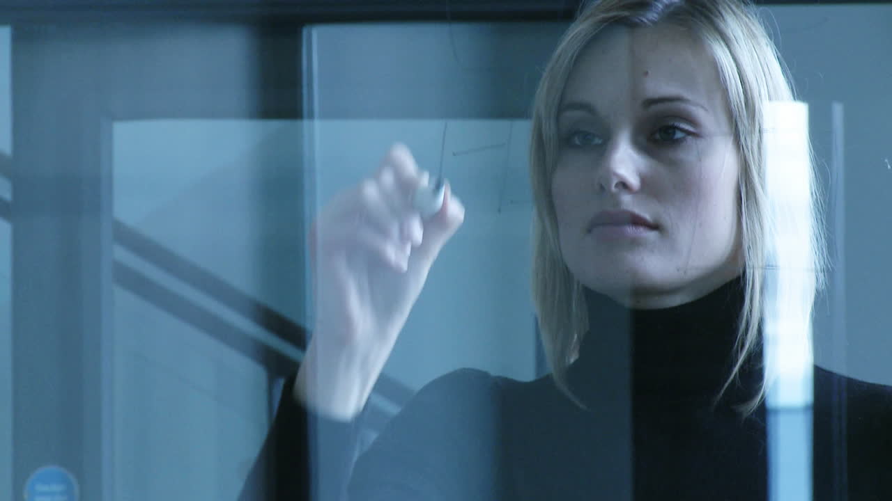 mujer de negocios escribiendo en vidrio