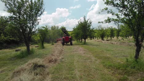 aerial flying over farmer working on a field with a hay baler