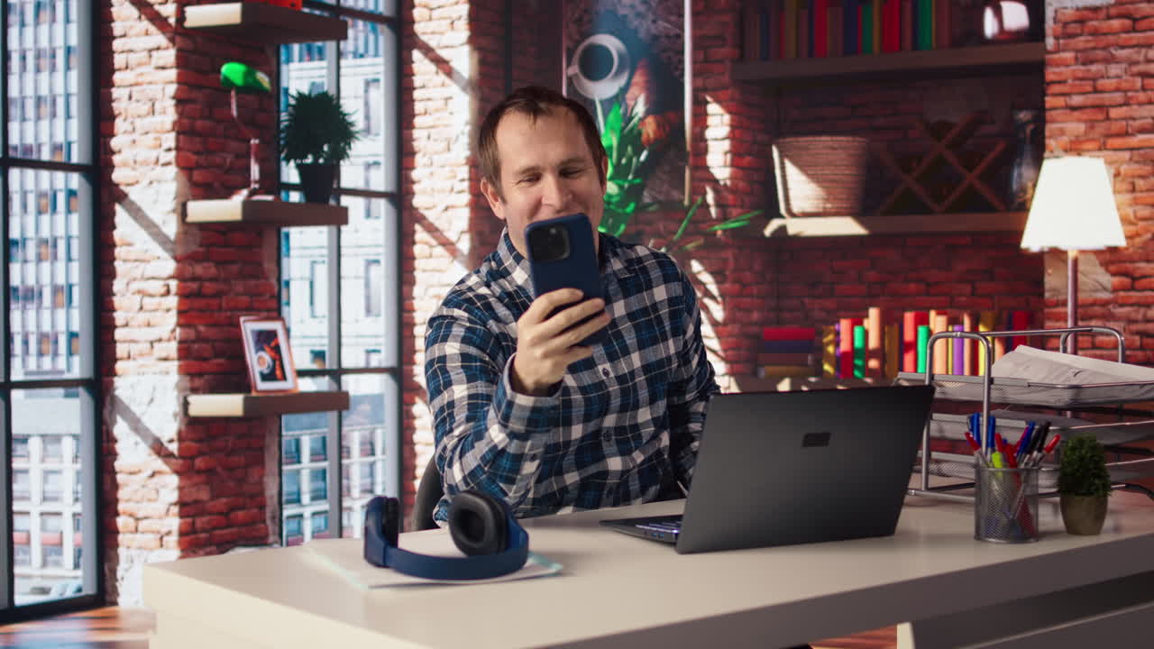 Un dipendente felice che saluta i colleghi in una videoconferenza telefonica