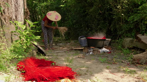 mujer recogiendo y preparando pajitas para colorear en una olla grande