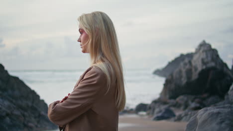 blonde girl posing coast in gloomy evening portrait. contemplative model turning